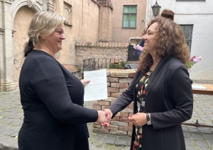 Sieviete sniedz otrai sievietei diplomu.