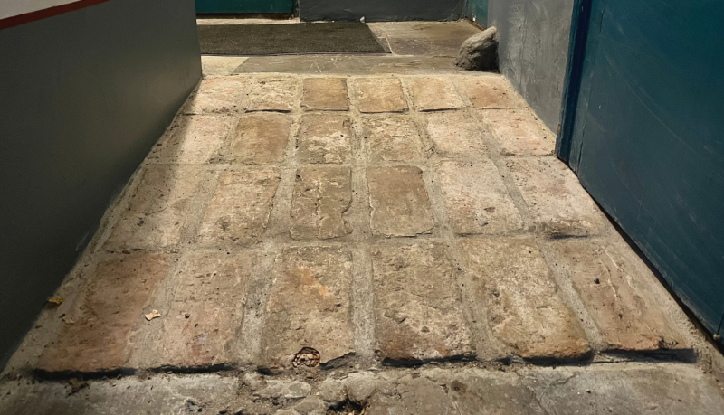 Attēlā redzama no seniem ķieģeļiem veidota slīpa uzbrauktuve, lai cilvēki ratiņkrēslā varētu nonākt Nacionālās kultūras mantojuma pārvaldes sapulču zālē.