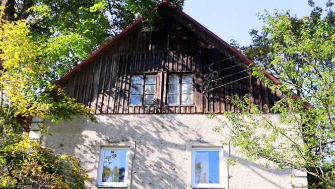 Trīs līmeņu dzirnavu māja. Pirmais līmenis ir akmens mūris, tajā ir koka durvis. Otrais līmenis ar diviem logiem ir apmests un trešais līmenis apšūts ar dēļiem, arī tur ir divi logi. Jumts divslīpju. Apkārt ir koki, māja ir sena.