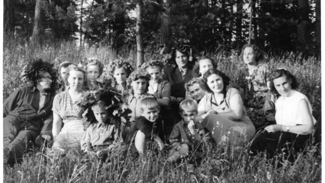 Melnbalts foto ar Jāņu svinētājiem pļavā