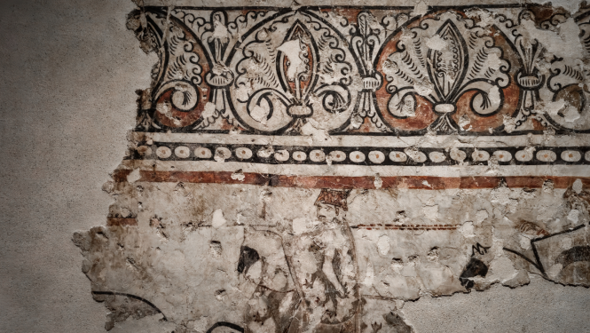 Daļēji saglabājies sienas gleznojums ar ģeometriskiem un augu ornamentiem. Gleznojums ir izbalējis un bojāts, atklājot sienas virsmu. augšpusē, zem tā ir horizontāla līnija ar punktveida elementiem.