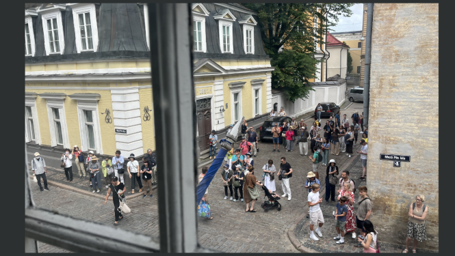 Rakstu ilustrējošs attēls ar tūristu pūli Vecrīgā. Aina uzņemta no Nacionālās kultūras mantojuma pārvaldes loga otrajā stāvā.