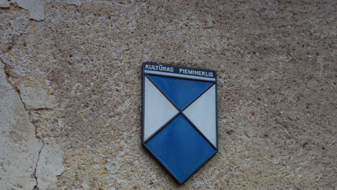 Pieminekļu zīme uz mūra virsmas