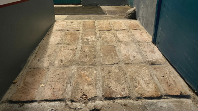 Attēlā redzama no seniem ķieģeļiem veidota slīpa uzbrauktuve, lai cilvēki ratiņkrēslā varētu nonākt Nacionālās kultūras mantojuma pārvaldes sapulču zālē.