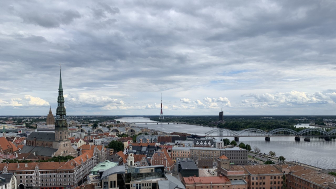 Attēlā redzams no gaisa uzņemts skats ar Rīgas vēsturiskā centra sirdi - Vecrīgu. Tajā redzami arī Vecrīgas kvartāli starp Kaļķu un Tirgoņu ielām, par kuru potenciālo apbūvi vēstī raksts. Attēlā redzama arī Daugava un dinamiskas debesis ar mākoņiem, bet tālumā paceļas Pētera baznīcas smaile.