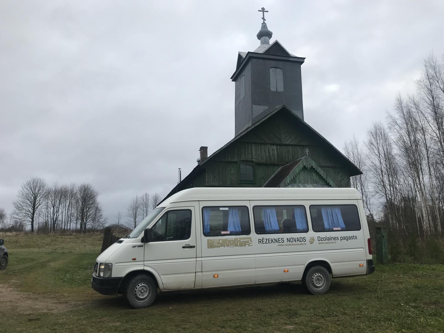 Kampišķu baznīca no ārpuses un mikroautobuss