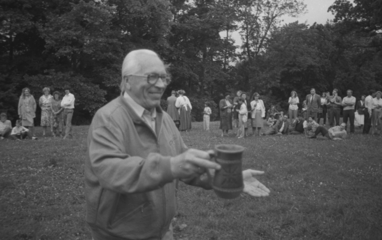 Vīrietis ar alus kausu Jāņu svinību laikā (melnbalts foto)