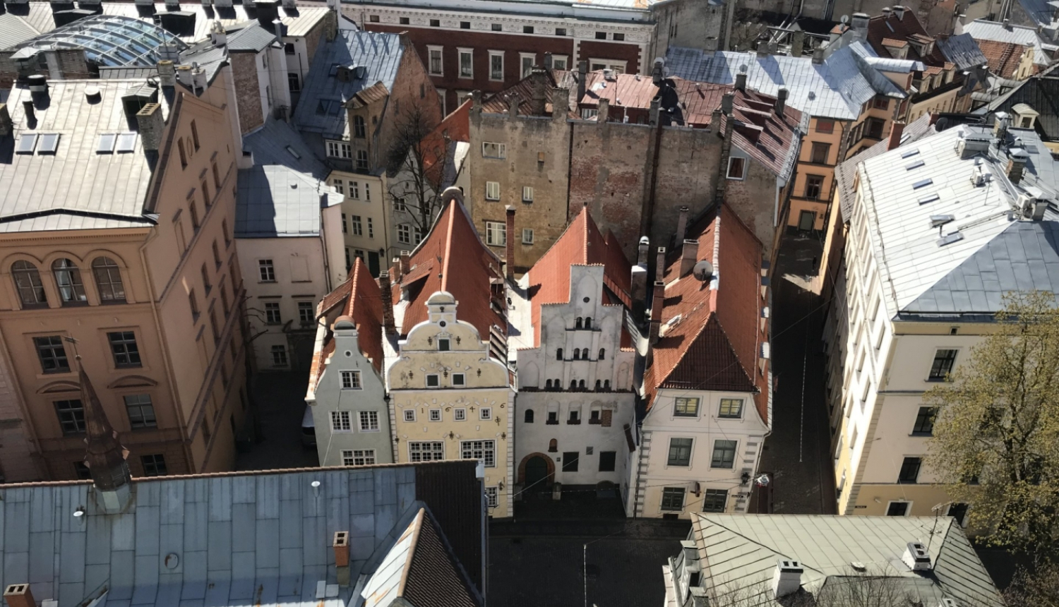 Ēku ansamblis "Trīs brāļi" - Nacionālās kultūras mantojuma pārvaldes mājvieta un vieta, kur jau daudzus gadus darbojas kultūras mantojuma aizsardzība. Skats no netālu esošās Jēkaba katedrāles torņa. Ēkas redzamas no augstuma centrā pa vidu, apkārt redzama plašāka ainava, Vecrīgas jumti.